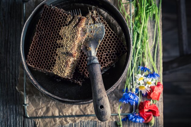 Herramientas oxidadas para la apicultura con sombreros de panales y miel.