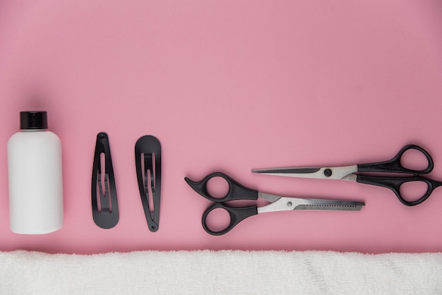 Herramientas de peluquería profesional. Equipo de estilista en fondo rosa.