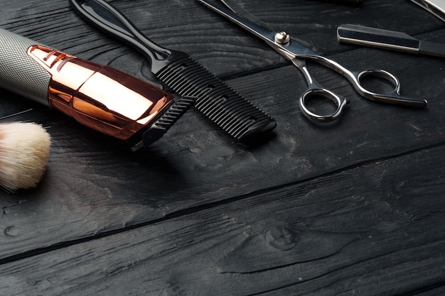 Foto las herramientas profesionales del barbero colocadas en una superficie de madera oscura