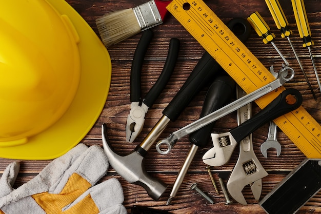 Herramientas del trabajador de construcción en el fondo de la tabla de madera.