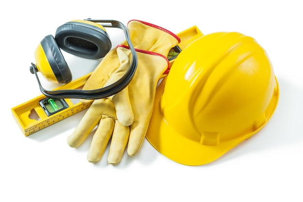 Herramientas de trabajo de construcción casco guantes nivel auriculares aislado sobre fondo blanco.