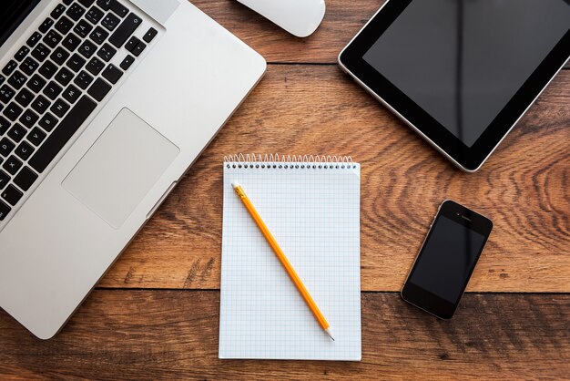 Herramientas de trabajo modernas. Vista superior del lugar de trabajo en la oficina con mesa de madera y portátil en él