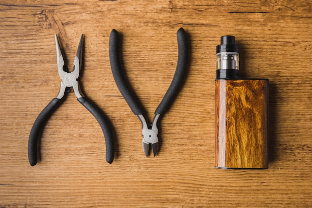 Herramientas de vapeo con fondo de madera y mod.