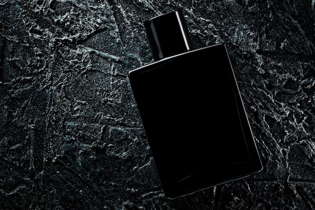 Herrenduft von Parfüm oder Eau de Toilette Werbefoto einer schwarzen Flasche auf dunklem Hintergrund Layout
