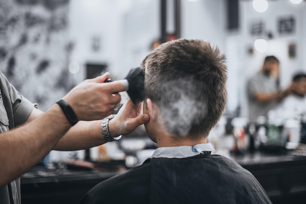 Herrenhaarschnitt im Schönheitssalon. Barber macht dem Kunden einen Haarschnitt. Vorbereitung für einen Haarschnitt.