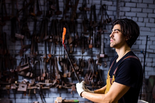 Herrero moreno italiano que trabaja en el taller