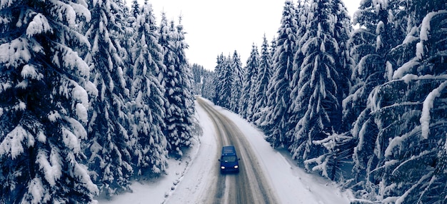 Herrliche Winterberglandschaft. Straße im verschneiten Winterwald. Drohnenansicht.