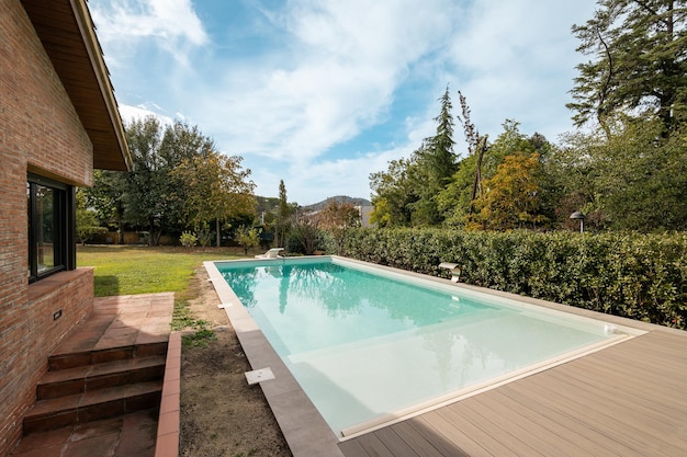 Herrlicher Blick auf den Hinterhof eines Landhauses mit einem Swimmingpool mit sauberem, klarem Wasser