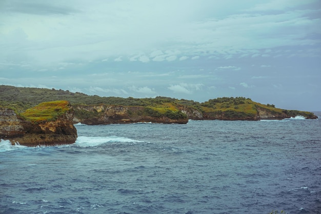 Herrlicher Blick auf einzigartige natürliche Felsen und Klippen in einem wunderschönen Strand, der als Angel's Billabong Beach bekannt ist und sich auf der Ostseite der Insel Nusa Penida, Bali, Indonesien, befindet. Luftaufnahme.