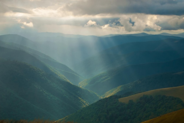 Herrliches Panorama auf die Berge. Die Sonnenstrahlen dringen durch die Wolken mitten im Tal.