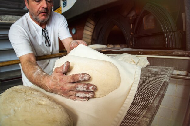 Herstellung von gebackenem Brot mit einem Holzofen in einer Bäckerei.