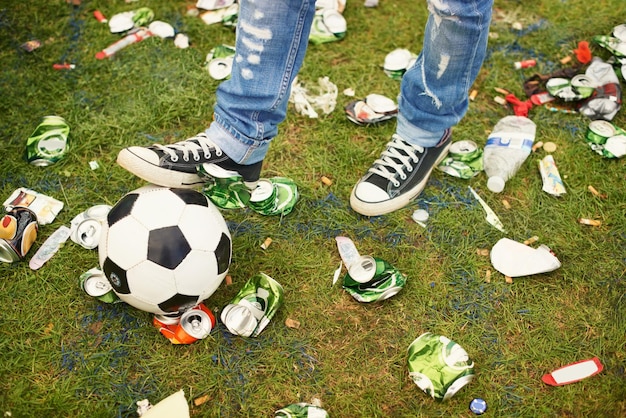 Herumtollen in den Folgen Eine Person, die mit einem Fußball inmitten des Mülls spielt, der bei einem Musikfestival zurückgelassen wurde