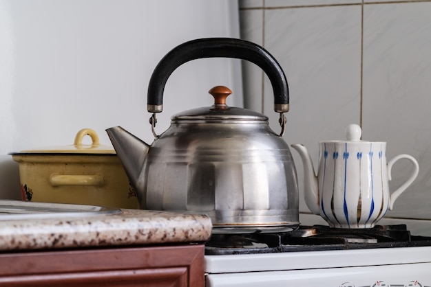 Foto hervidor y olla en una estufa de gas, preparación de té