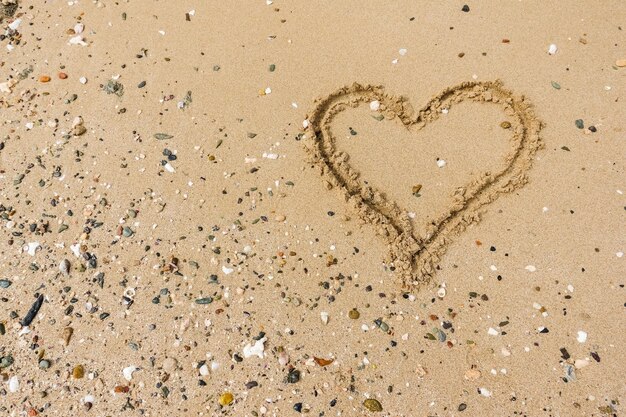 Foto herz auf dem sandstrand im urlaub.