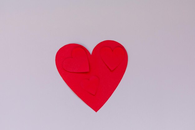 Herz aus Papierhandwerk auf einem rosa Hintergrund Valentine flach lag mit rotem Herz