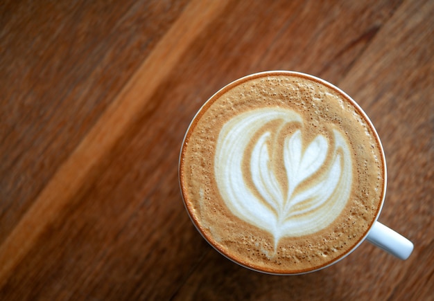 Herz geformter Kaffee Latte auf hölzernem.