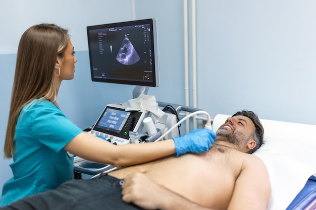 Herz-Ultraschalluntersuchung durchgeführt von Ärztin mit lächelnder Patientin