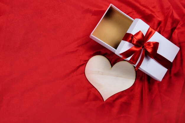 Herz und Geschenkbox mit farbigem Hintergrund. Valentinstag