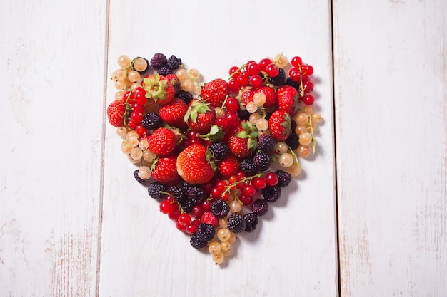 Herz von Mischbeeren auf weißem Holz