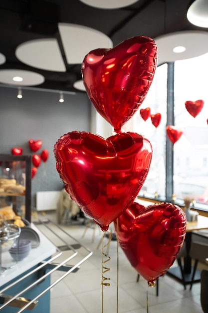 Herzen aus roten Folienballons mit Helium im Dekor des Cafés am Valentinstag