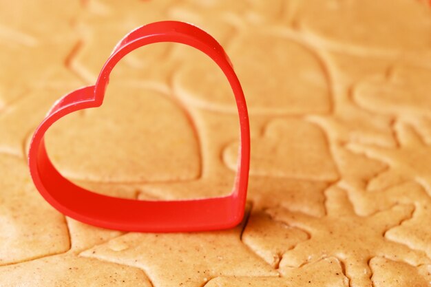 Herzförmige Backform zur Herstellung von Lebkuchen auf dem Teig. St. Valentines Süßigkeiten