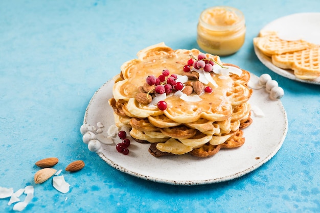 herzförmige belgische Waffeln auf blauem Hintergrund Europäische Gebäck Süßigkeiten St. Valentinstag