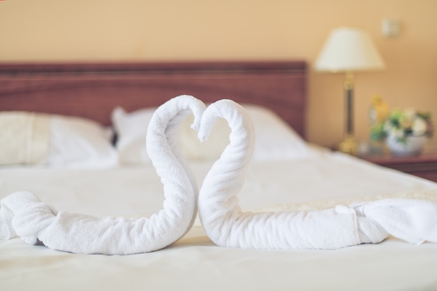 Herzförmige Handtücher liegen auf dem Bett im Hotelzimmer