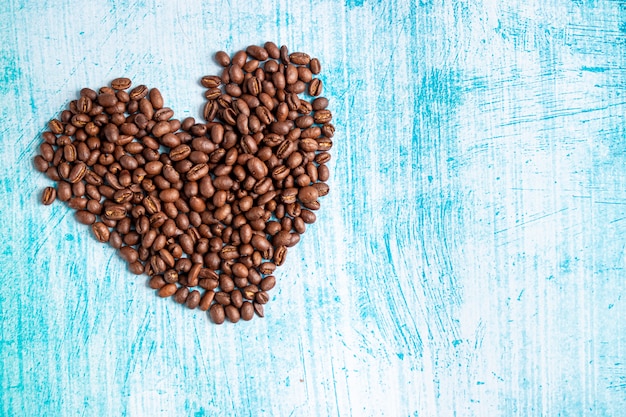 Herzförmige Kaffeekörner auf Aquamarinhintergrund