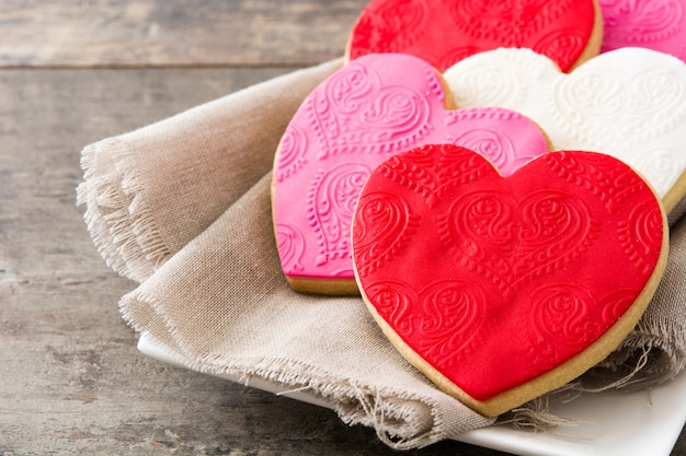 Herzförmige Kekse zum Valentinstag auf Holztisch Copyspace