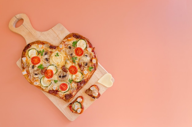 herzförmige Pizza mit Kirschtomaten, Käse zum Valentinstag im Hintergrund. Ansicht von oben. Attrappe, Lehrmodell, Simulation