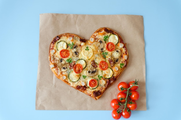 herzförmige Pizza mit Kirschtomaten, Käse zum Valentinstag im Hintergrund. Ansicht von oben. Attrappe, Lehrmodell, Simulation
