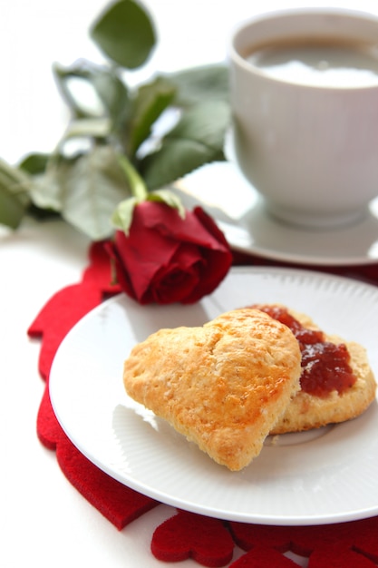 Herzförmige Scones mit Erdbeermarmelade und einer Tasse Tee