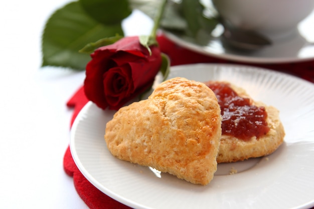 Herzförmige Scones mit Erdbeermarmelade und einer Tasse Tee