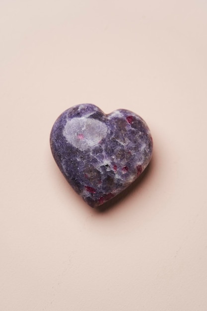 Herzförmiger Kristallstein auf rosa Hintergrund mit Draufsicht auf den Kopierbereich Liebes- und Valentinstagskonzept