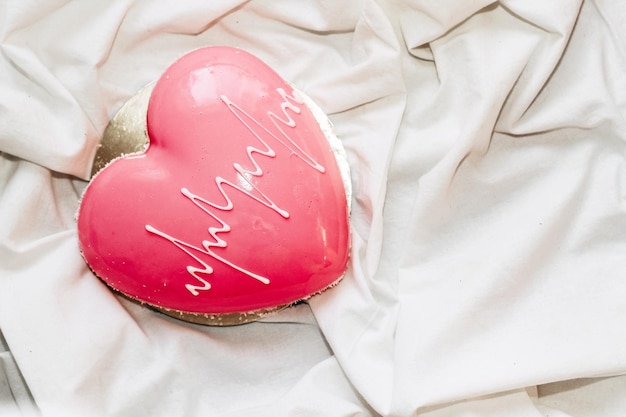 Herzförmiger rosa Mousse-Kuchen auf dem Tisch