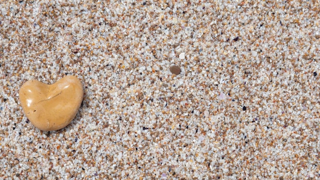 Herzförmiger Stein auf dem Strandsand