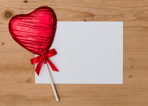 Herzförmiges Bonbonlutscher-Valentinstaggeschenk mit einer leeren weißen Mitteilung