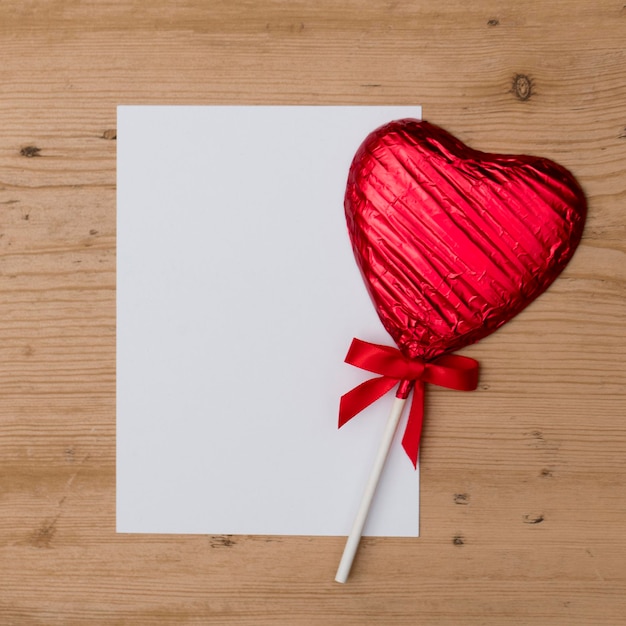 Herzförmiges Bonbonlutscher-Valentinstaggeschenk mit einer leeren weißen Mitteilung