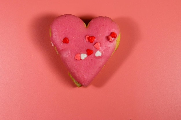 Herzförmiges Plätzchen auf rosa Hintergrund Ansicht von oben Dessert zum Valentinstag