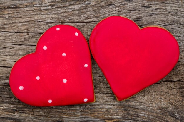 Herzförmiges Plätzchen zum Valentinstag auf rustikalem Holztisch. Ansicht von oben