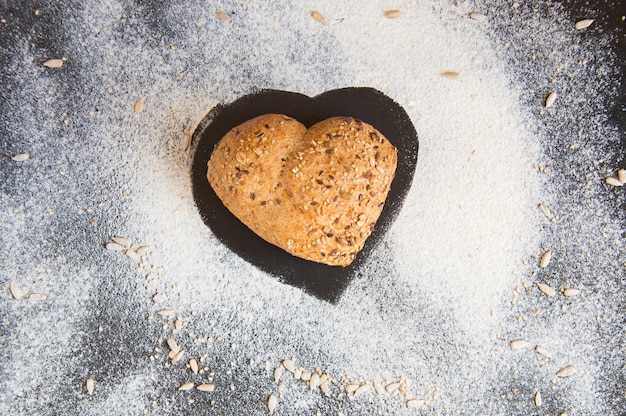 Herzform aus Vollkornbrot auf Tafelhintergrund