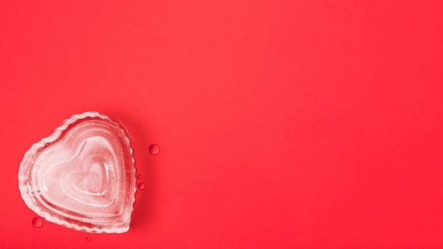 Herzform-Eiswürfel auf rotem Hintergrund mit Kopienraum, glücklicher Valentinstag, Muttertag, flache Lage, Draufsicht