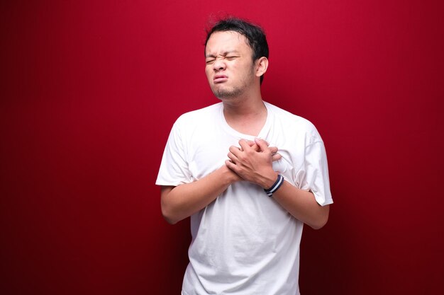 Herzinfarkt oder gebrochenes Herz eines jungen asiatischen Mannes mit verletzten Emotionen tragen ein schwarzes Hemd