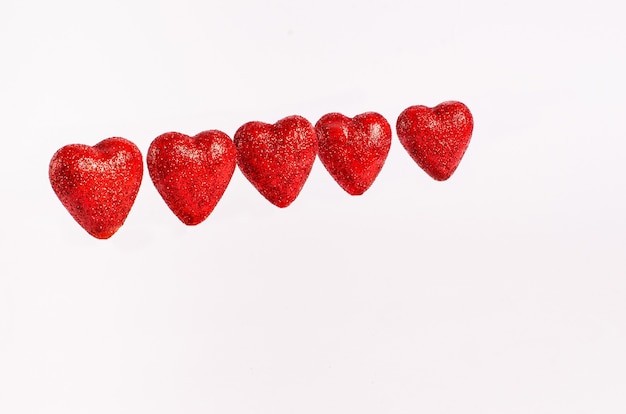 Herzrot glitzert zum Valentinstag auf einem glänzenden Hintergrund
