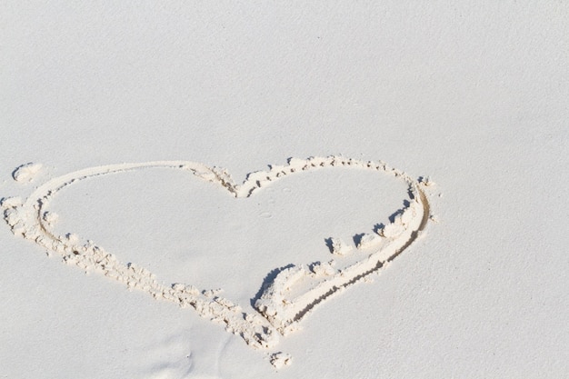 Herzzeichnung am Strand mit Welle.