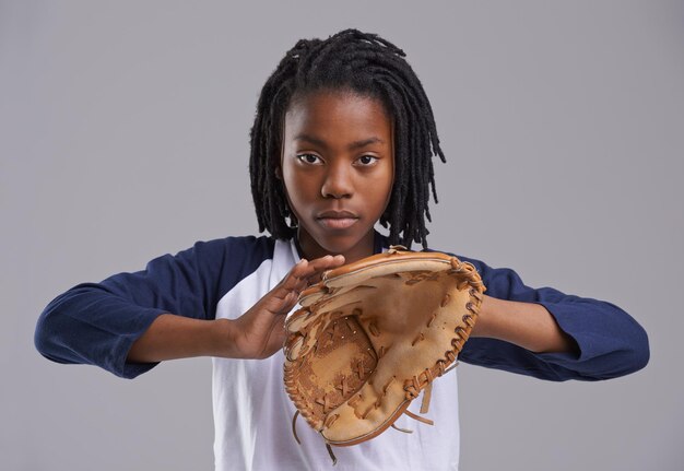 Hes a catch Foto de estudio de un joven con equipo de béisbol