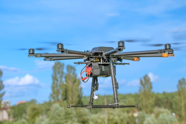 Hexacopter potente casero negro grande sobre una superficie de cielo azul, primer plano