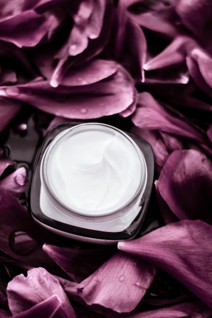 Hidratante de crema facial de lujo para la piel facial sobre fondo de flor rosa Cosméticos de spa floral essense y emulsión de belleza para productos de marca para el cuidado de la piel