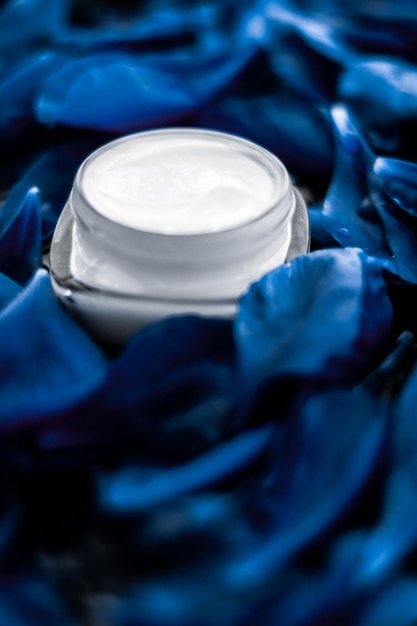 Hidratante de crema facial de lujo para la piel facial sobre fondo de flores azules cosméticos de spa floral essense y emulsión de belleza para productos de marca para el cuidado de la piel