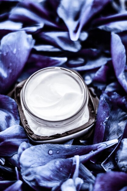 Hidratante de creme de rosto de luxo para pele facial em fundo de flor azul, cosméticos de spa floral essense e emulsão de beleza para produtos de marca de cuidados com a pele